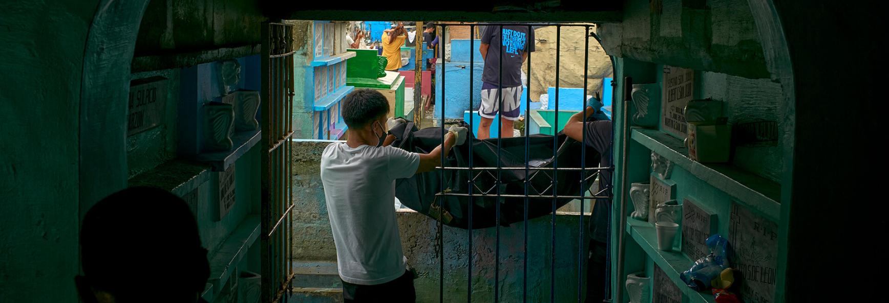 Family members and members of the Catholic church exhume the remains of victims of government extrajudicial killings ahead of International Human Rights Day, on December 7, 2021 inside a public cemetery in the suburbs of Manila, Philippines. 