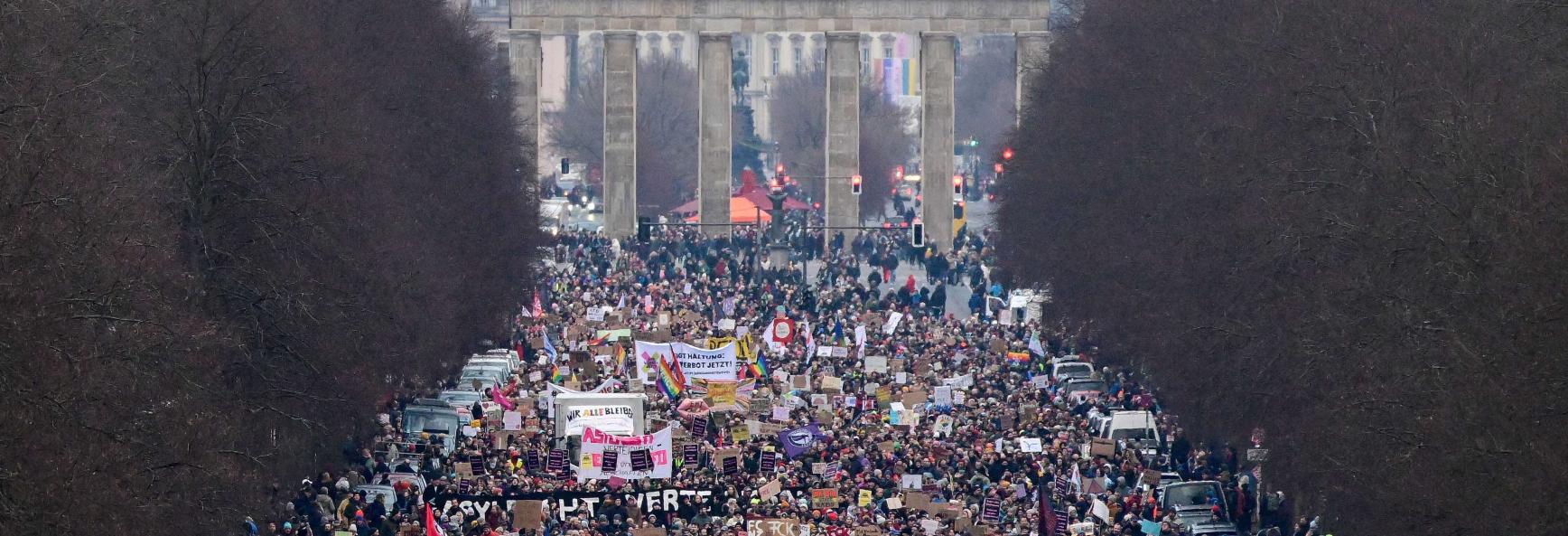rotesters take part in a demostration under the motto 'Loud against Nazis' with the landmak Brandenburg Gate in the background in Berlin on February 2, 2025. 