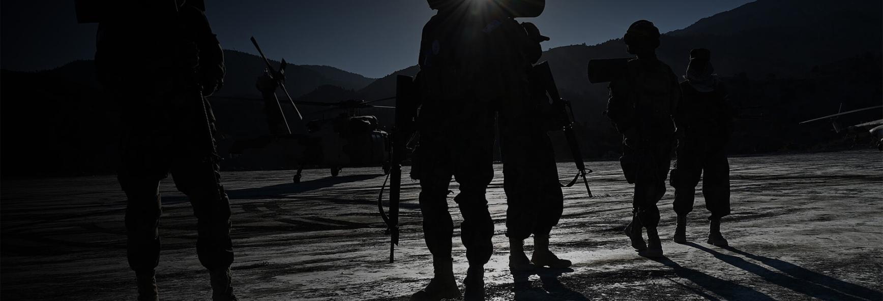 Taliban security personnel stand guard as a helicopter prepares to take off after the funeral ceremony of Khalil Ur-Rahman Haqqani, the Minister for Refugees and Repatriation, in Sarana of Paktia province, south of Kabul, on 12 December 2024. 