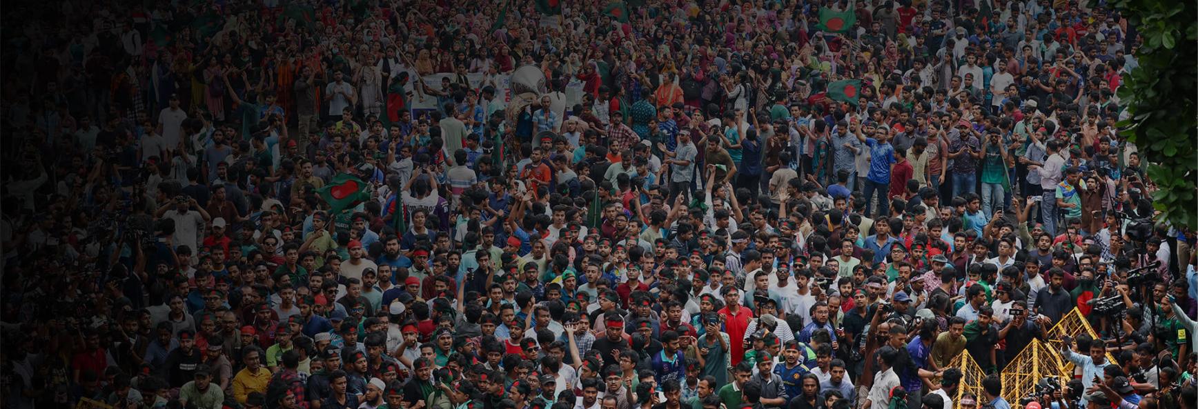 Students and job seekers are pushing a police riot jeep while crossing the police barricade and shouting slogans by blocking a road as they are protesting to ban quotas for government jobs in Dhaka, Bangladesh, on 11 July 2024.