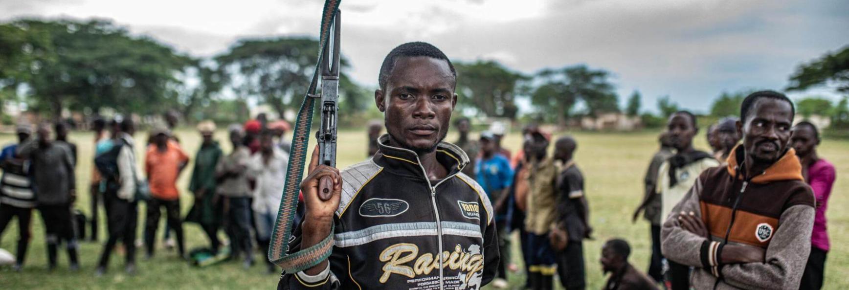 A Wazalendo militant surrenders a weapon to members of the M23 on 15 December 2025 in Uvira.
