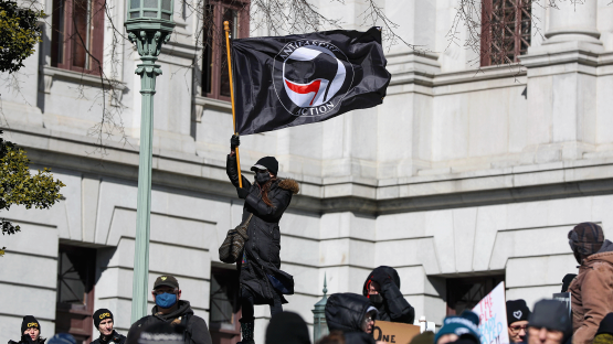 A protester waves an Antifascist Action flag during the "No Kings Day" protest demonstration in Harrisburg, Pennsylvania, Unites States on 17 February 2025. 