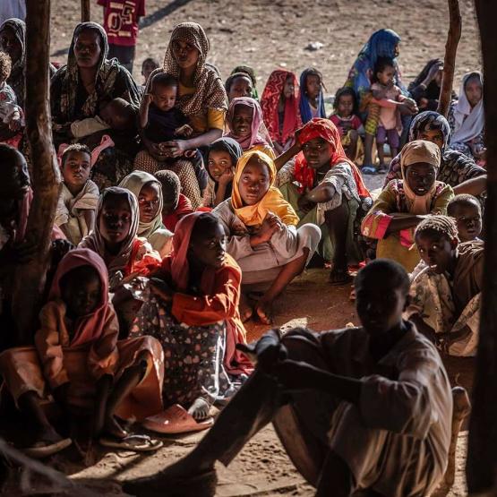 Sudanese refugees and ethnic South Sudanese families who have fled from the war in Sudan gather after crossing the border while waiting to be registered by the authorities at the Joda Border Crossing 