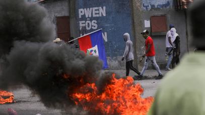 Photo of demonstrators passing by fire and smoke amid a protest demanding an end to gang violence, in Port-au-Prince, Haiti, August 14, 2023.