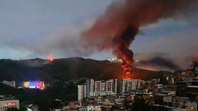 Fire at Fuerte Tiuna, Venezuela's largest military complex, is seen from a distance after a series of explosions in Caracas on January 3, 2026. Photo by AFP via Getty Images.