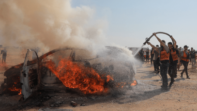 Firefighters attempt to extinguish a fire following an Israeli airstrike that hit a vehicle and killed a senior police official in Gaza City on 13 August 2026. 