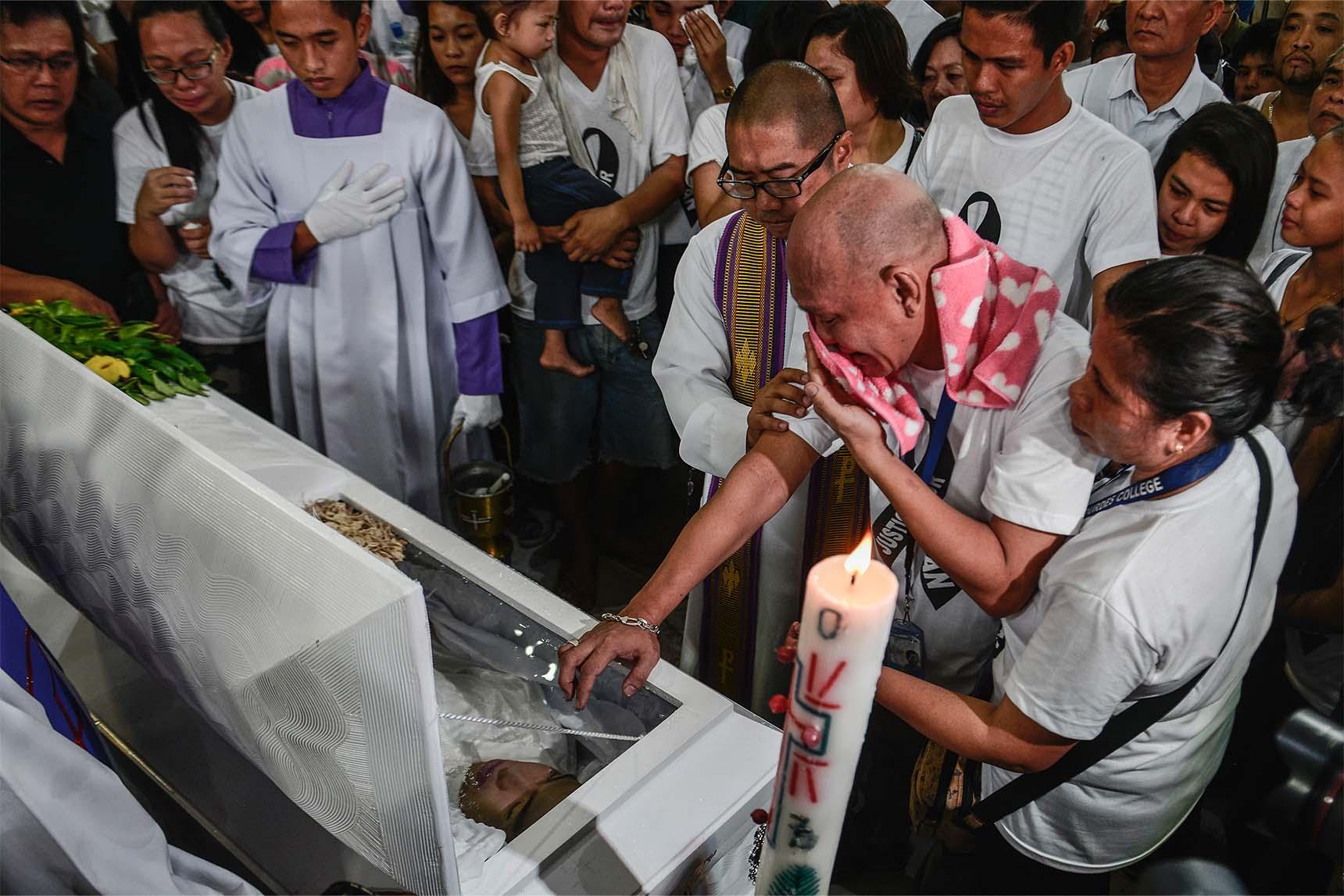 The parents and relatives of Kian Loyd Delos Santos weep over his coffin during his funeral rites in Caloocan, Metro Manila, Philippines, 26 August 2017